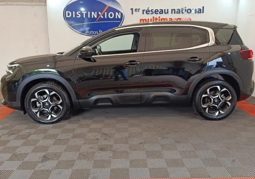Profil droit d'un Citroën C5 Aircross noir 2024 avec toit clair et jantes alliage au design moderne.