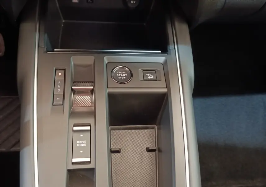 Vue rapprochée de la console centrale noire du Citroën C5 Aircross 2024 avec bouton start/stop et commandes de boîte auto.
