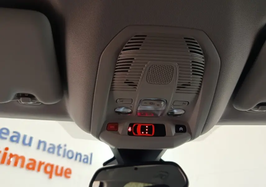 Vue intérieure du plafonnier gris clair avec commandes d’éclairage et bouton SOS du Citroën C5 Aircross 2024 noir.