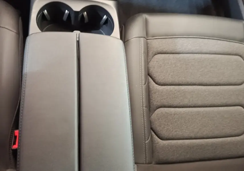 Vue rapprochée de l'accoudoir central noir et du siège passager en tissu et cuir du Citroën C5 Aircross 2024.