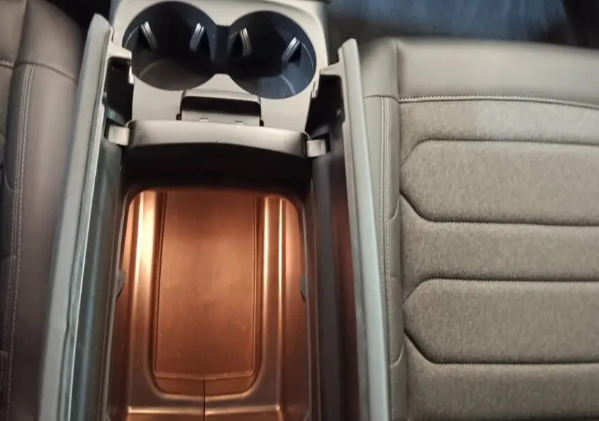 Vue plongeante sur la console centrale ouverte du Citroën C5 Aircross 2024, intérieur gris avec porte-gobelets visibles.