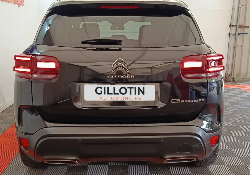 Vue arrière d'un Citroën C5 Aircross noir 2024 avec feux LED allumés et double sortie d'échappement visible.
