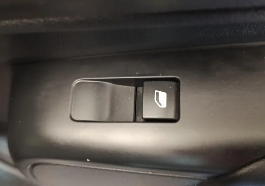 Gros plan sur le bouton de commande de vitre électrique noir dans l'habitacle du Citroën C5 Aircross 2024.