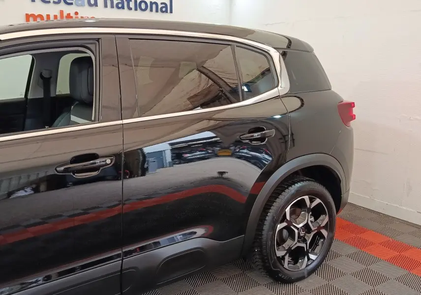 Vue latérale côté droit du Citroën C5 Aircross noir 2024, mettant en valeur la roue arrière et les vitres teintées.