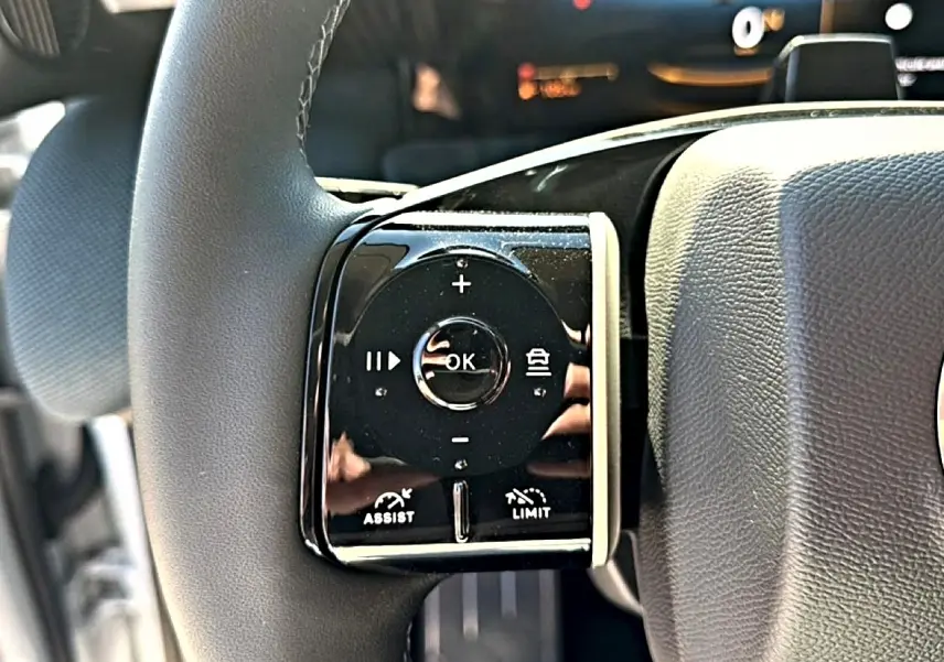Gros plan sur les commandes multifonctions à gauche du volant du Citroën C5 Aircross hybride 2026.