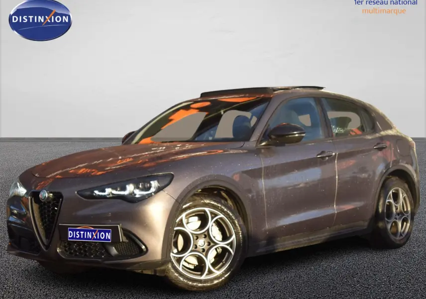 Alfa Romeo Stelvio 2024 gris Vesuvio en 3/4 avant droit avec toit panoramique et jantes alliage 19 pouces.