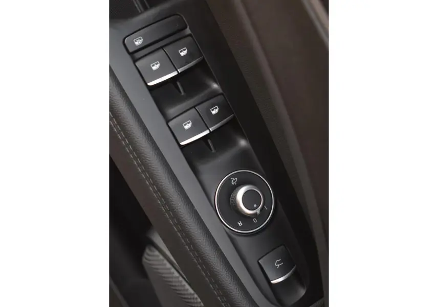 Gros plan sur les commandes des vitres et rétroviseurs côté conducteur de l'Alfa Romeo Stelvio 2024, intérieur noir.