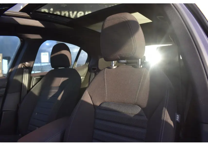 Vue intérieure de l'Alfa Romeo Stelvio 2024 montrant les sièges avant noirs et le toit ouvrant panoramique.