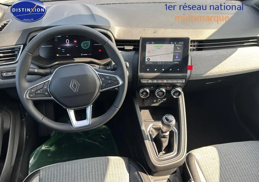 Vue intérieure avant de la Renault Clio V 1.0 TCe 90 Techno, tableau de bord gris avec écran tactile et boîte manuelle.