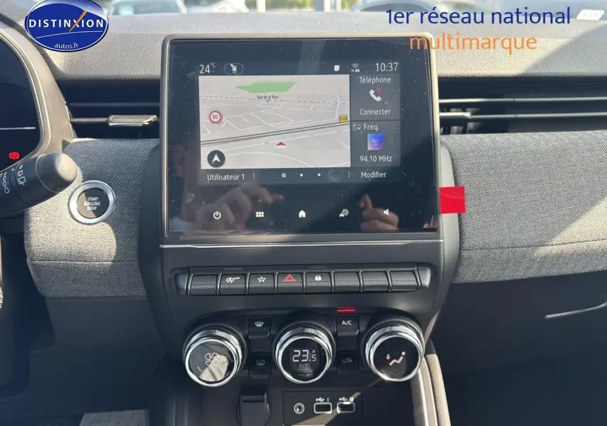 Vue rapprochée du tableau de bord de la Renault Clio V gris schiste, avec écran tactile et commandes de climatisation.