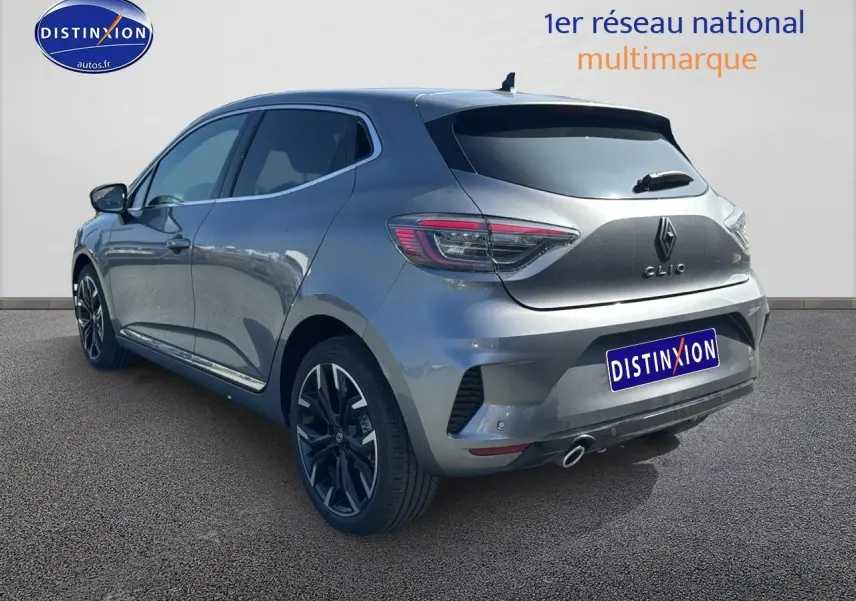 Renault Clio V gris schiste vue 3/4 arrière droit, jantes alu noires et feux arrière LED distinctifs.