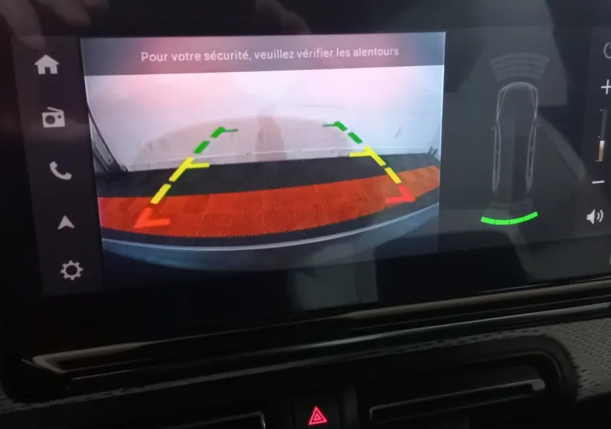 Écran tactile de la Citroën C3 hybride 2025 affichant la caméra de recul avec guidage coloré et alertes de sécurité.