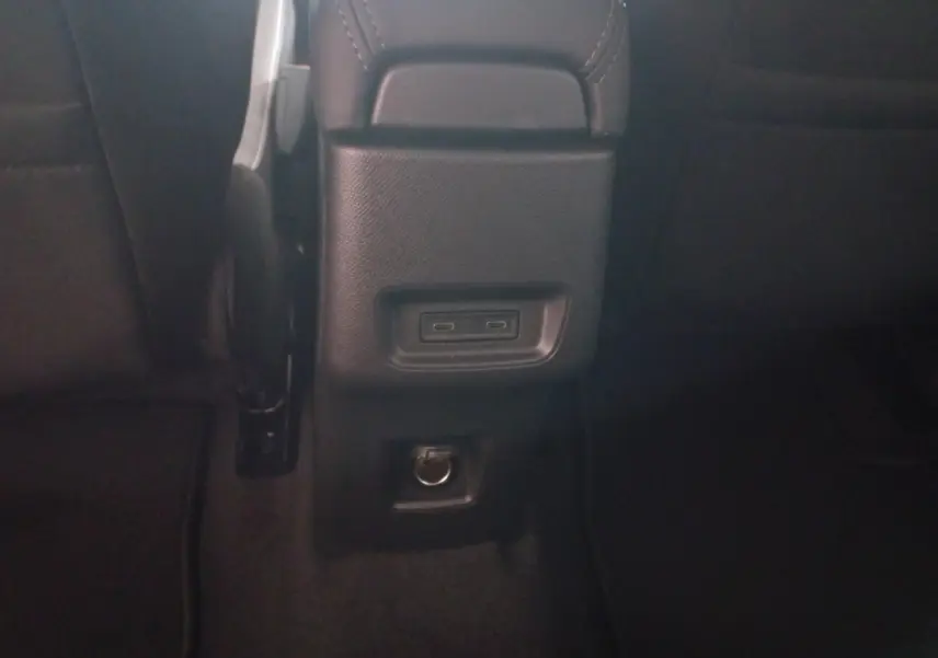 Vue rapprochée de la console arrière noire de la Citroën C3 hybride 2025 avec ports USB-C et prise 12V.