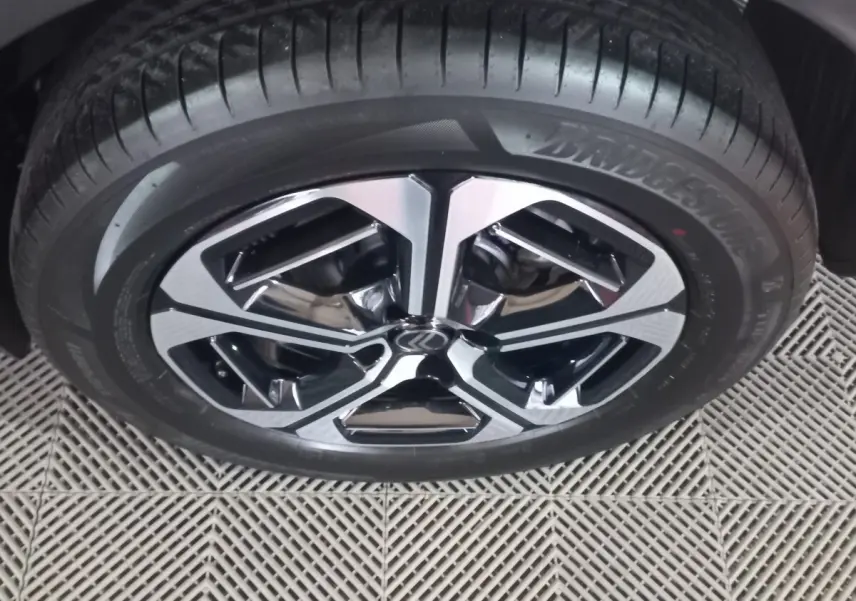 Gros plan sur la roue avant droite de la Citroën C3 hybride 2025 avec jante alliage bicolore et pneu Bridgestone.