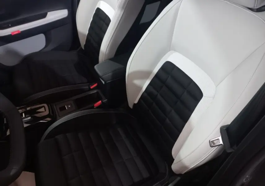 Vue intérieure rapprochée des sièges avant bicolores noir et blanc de la Citroën C3 Hybride 2025.