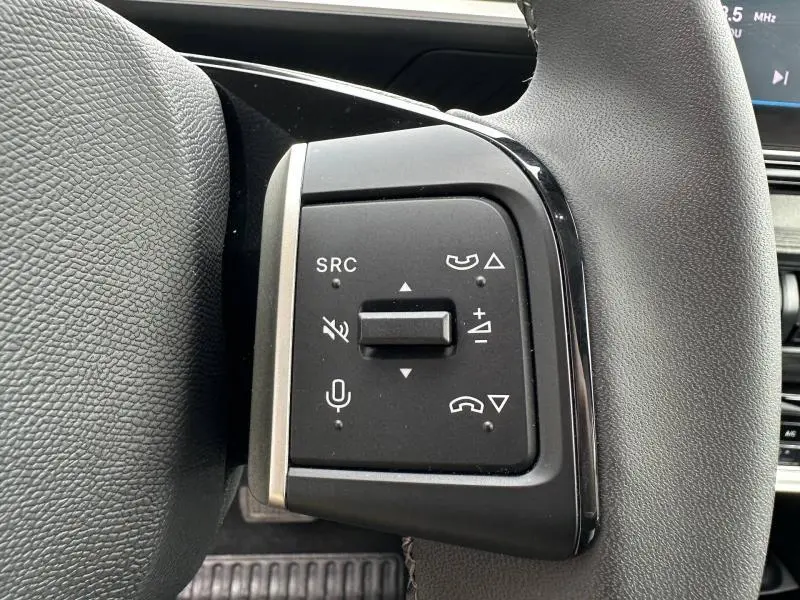 Gros plan sur les commandes multifonctions noires à gauche du volant du Citroën C3 électrique 2025, finition Noir Perla Nera.