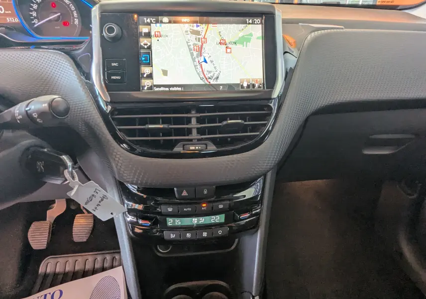 Vue intérieure centrée sur la console centrale du Peugeot 2008 gris, avec écran GPS et commandes de climatisation visibles.