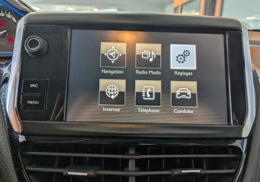 Écran tactile central du tableau de bord du Peugeot 2008 gris, affichant les options Navigation, Radio, Réglages, Internet, Téléphone et Conduite.