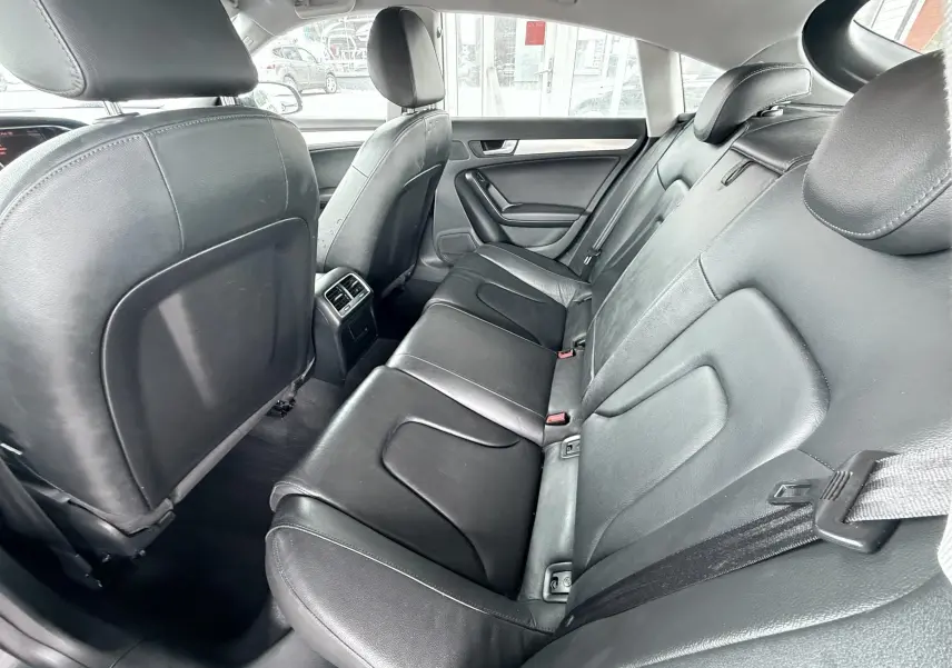 Vue intérieure arrière de l’Audi A5 Sportback 2009 avec sièges en cuir noir et ceinture de sécurité visible.