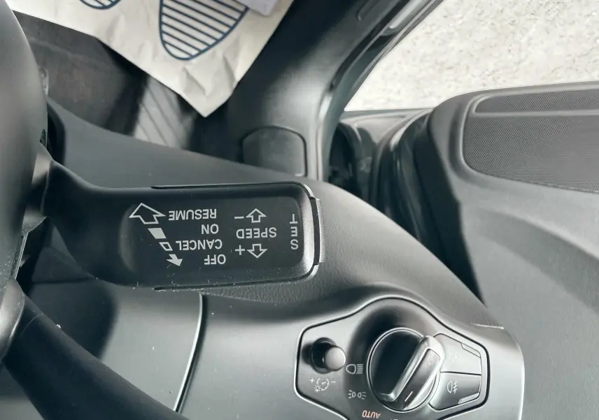 Détail du commodo de régulateur de vitesse et commande des phares côté gauche dans l’habitacle gris d’une Audi A5 Sportback.