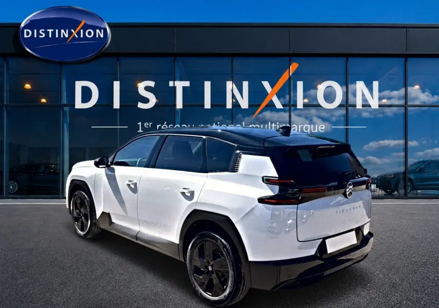 Vue 3/4 arrière droite du Citroën C5 Aircross 2026 blanc avec toit noir et jantes alliage noires devant un showroom Distinxion.