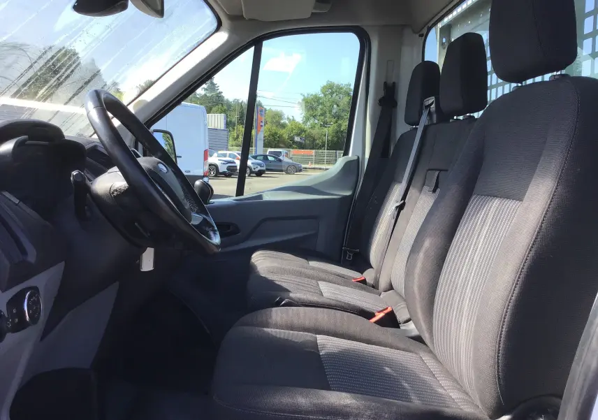 Intérieur du Ford Transit Chassis Cabine blanc, vue côté gauche sur les sièges avant et le volant, finition tissu noir.