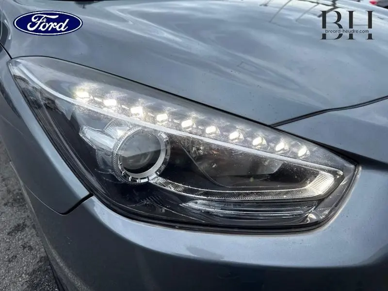 Gros plan sur le phare avant droit d'une Ford gris métallisé avec éclairage LED diurne allumé.