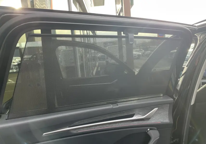 Vue intérieure côté gauche de la porte arrière d'un Skoda Kodiaq noir métal avec pare-soleil intégré.