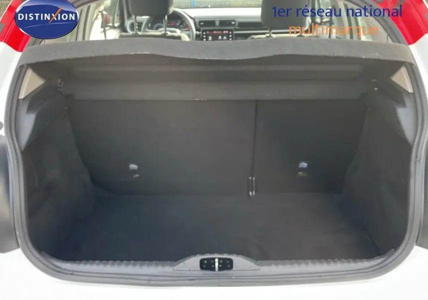 Coffre ouvert d’une Citroën C3 blanche avec toit rouge, vue arrière montrant l’espace de chargement vide.
