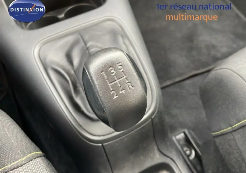 Gros plan sur le levier de vitesses manuel d'une Citroën C3 blanc toit rouge, intérieur tissu noir.