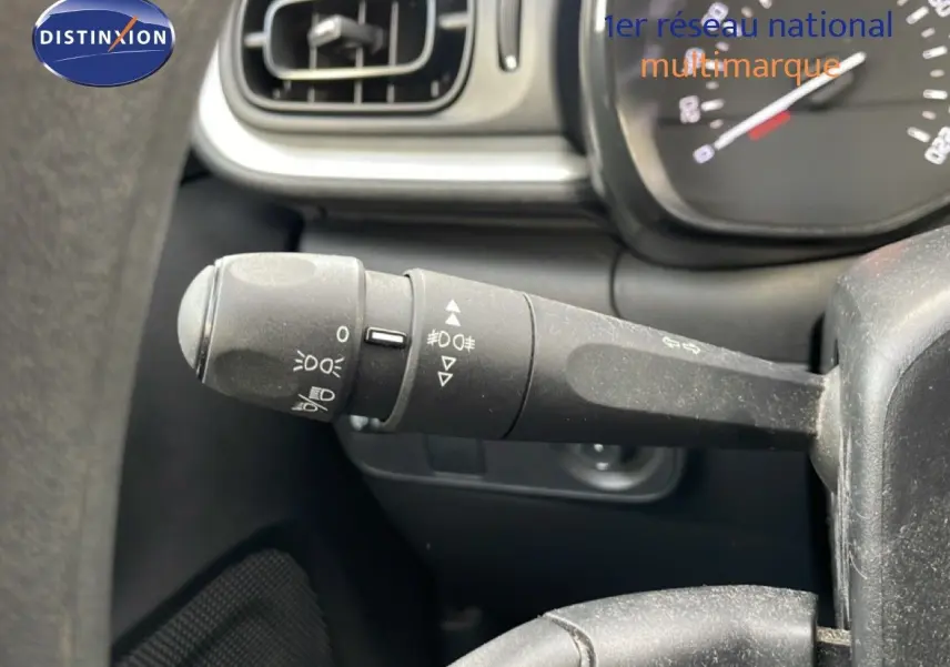 Gros plan sur la commande des feux à gauche du volant d’une Citroën C3 2018, intérieur noir.