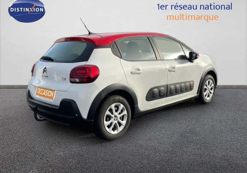 Vue 3/4 arrière droite d'une Citroën C3 blanche au toit rouge avec protections Airbump noires sur les portières.