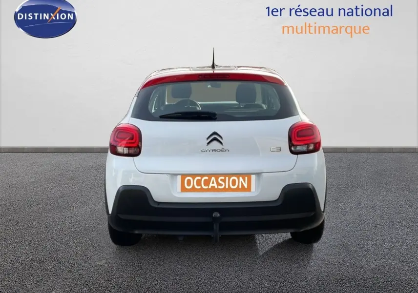 Vue arrière d'une Citroën C3 blanche avec toit rouge, feux arrière arrondis et plaque "OCCASION" visible.