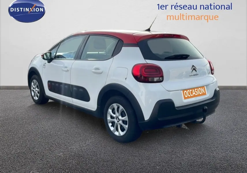 Vue 3/4 arrière droite d'une Citroën C3 blanche au toit rouge avec protections Airbump noires sur les portières.