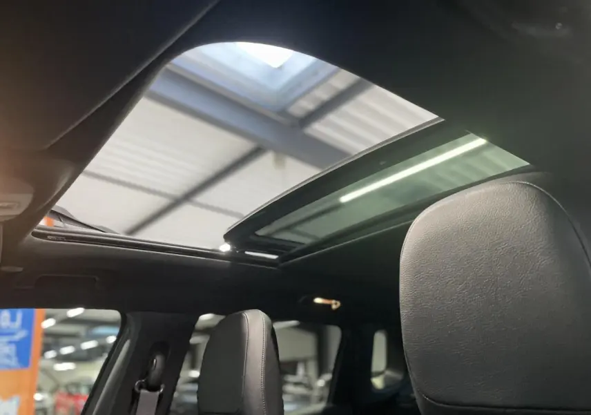 Vue intérieure du toit ouvrant panoramique CommandView du Jeep Compass Trailhawk avec sièges cuir noirs.