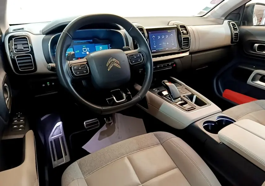 Vue intérieure avant droite du Citroën C5 Aircross Hybrid 225 avec volant cuir, écran tactile et console centrale beige et noire.