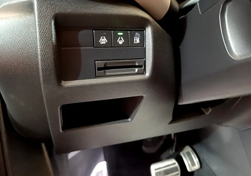Détail intérieur côté gauche montrant les commandes d'assistance et la pédale dans un Citroën C5 Aircross Hybrid blanc.