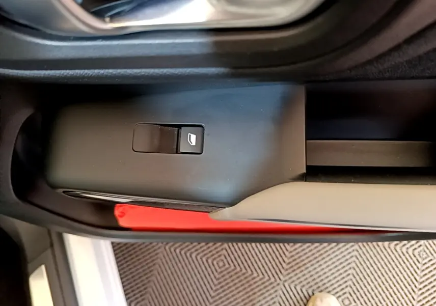 Détail du bouton de commande de la vitre sur la porte côté gauche du Citroën C5 Aircross Hybrid blanc.
