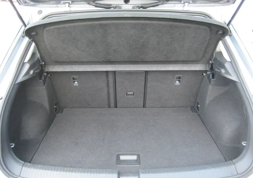 Coffre ouvert du Volkswagen T-Roc gris clair 2023, montrant un espace de chargement propre et bien agencé.