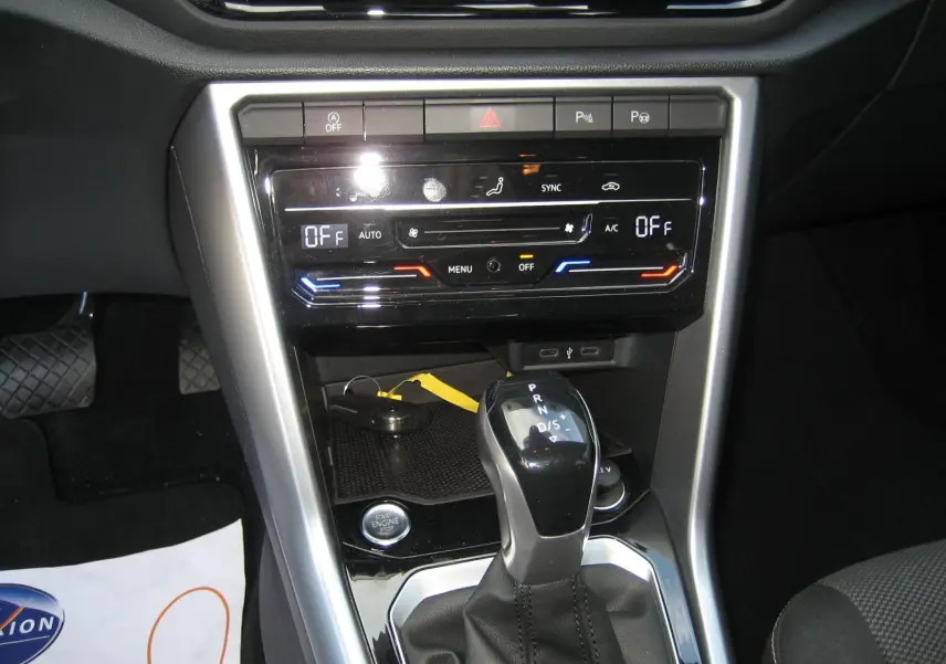 Vue rapprochée de la console centrale du Volkswagen T-Roc 2023, montrant la boîte auto DSG et les commandes de climatisation.