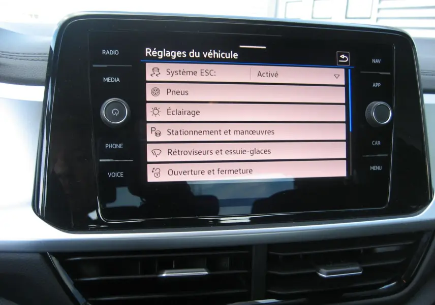 Écran tactile central du Volkswagen T-Roc 2023 affichant les réglages du véhicule dans un intérieur moderne.