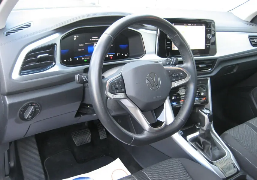 Vue intérieure du tableau de bord et volant du Volkswagen T-Roc 2023, avec écran tactile et commandes au volant.
