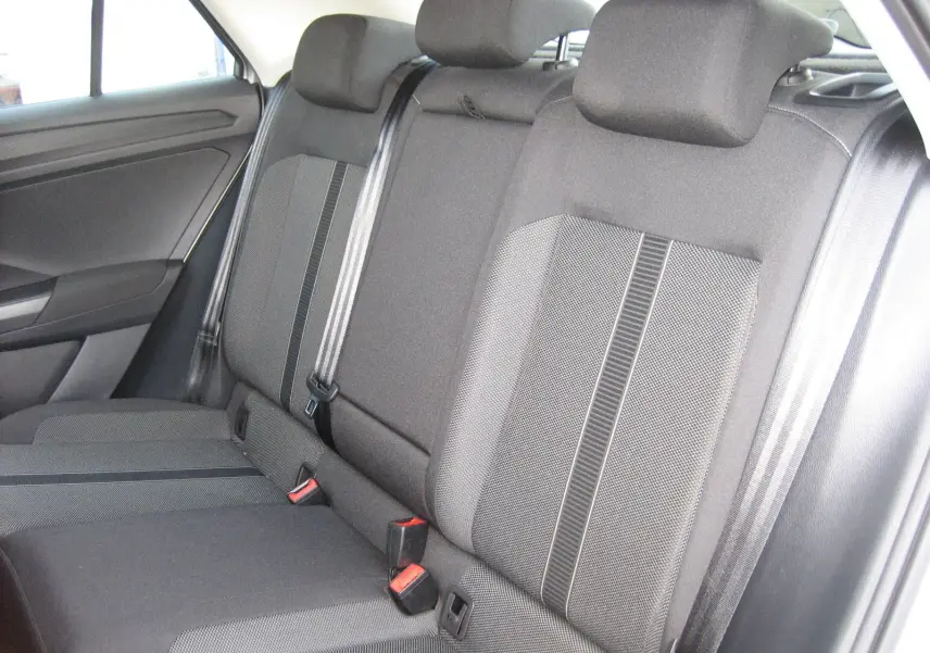 Vue intérieure montrant la banquette arrière grise foncée du Volkswagen T-Roc 1.5 TSI 2023 avec ceintures de sécurité visibles.