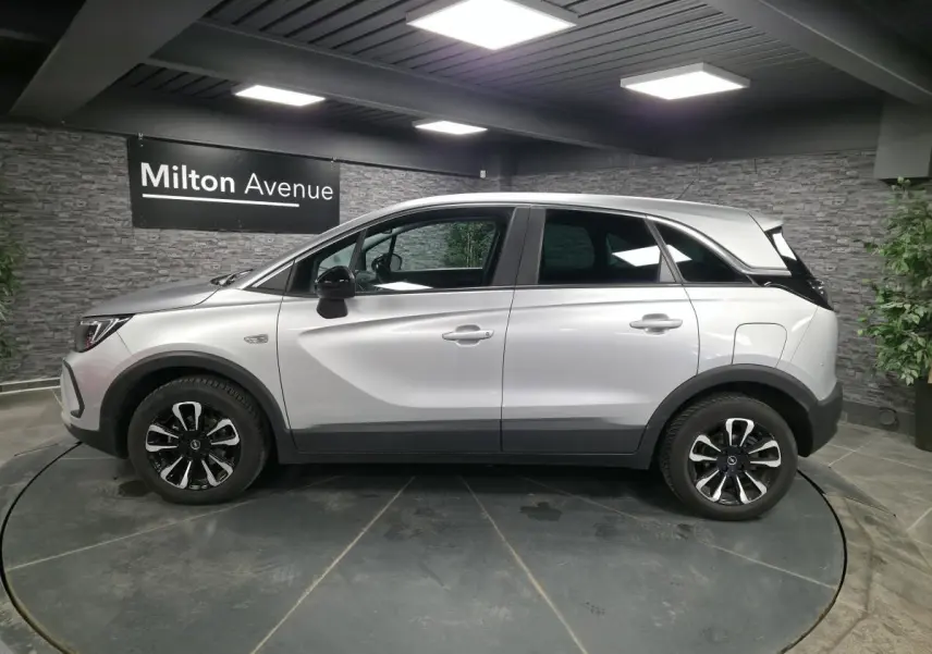 Opel Crossland gris métallisé vue de profil côté gauche, avec jantes alliage noires et coques de rétroviseurs noir karbon.