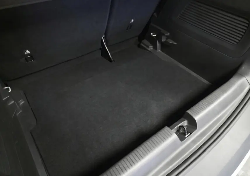 Vue rapprochée du coffre vide de l’Opel Crossland gris, montrant le revêtement noir et les fixations Isofix.