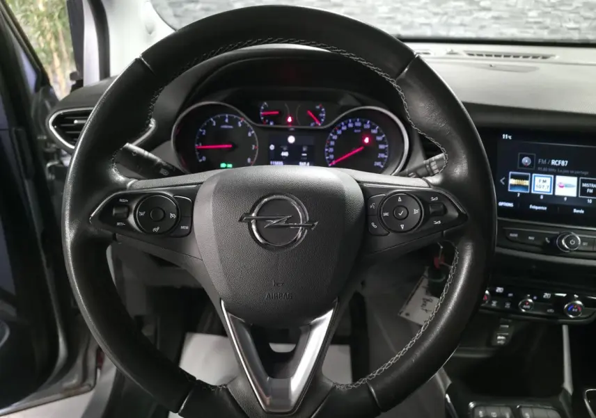 Vue rapprochée du volant noir de l’Opel Crossland 2023 avec tableau de bord et écran tactile multimédia.