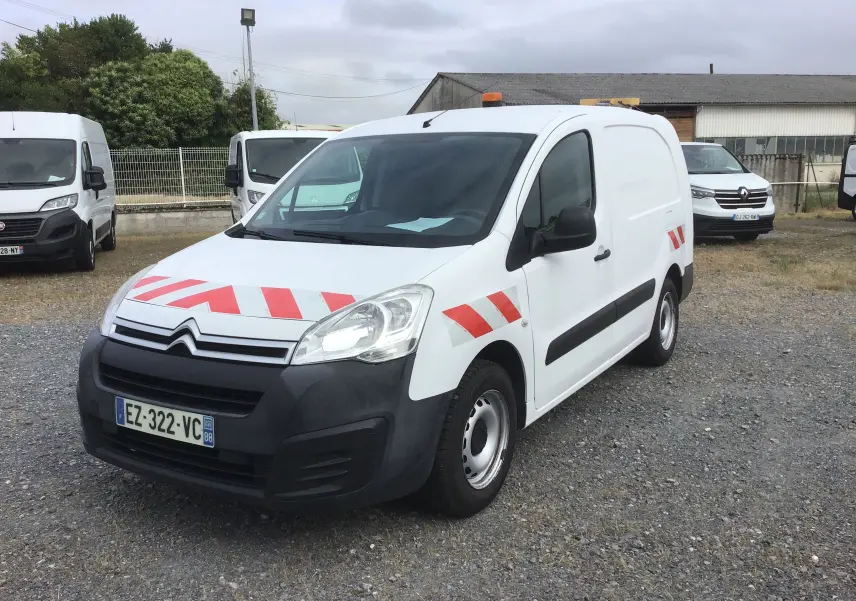 Vue 3/4 avant droit d’un Citroën Berlingo XL blanc avec bandes rouges réfléchissantes et gyrophare orange sur le toit.