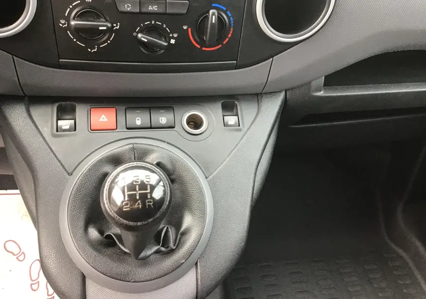 Vue rapprochée du levier de vitesses manuel et des commandes de climatisation du Citroën Berlingo blanc de 2018.