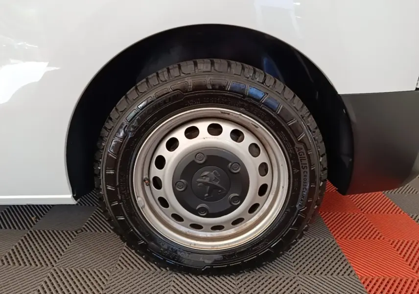 Gros plan sur la roue arrière droite blanche du Peugeot Expert Fourgon 2023 avec jante acier et logo Peugeot central.