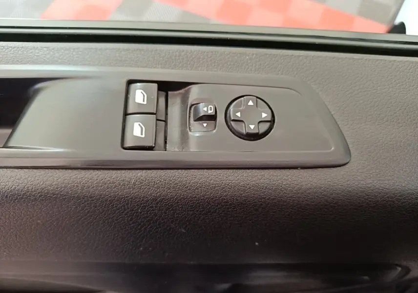Gros plan sur les commandes de réglage des rétroviseurs électriques sur la porte intérieure noire du Peugeot Expert Fourgon blanc.